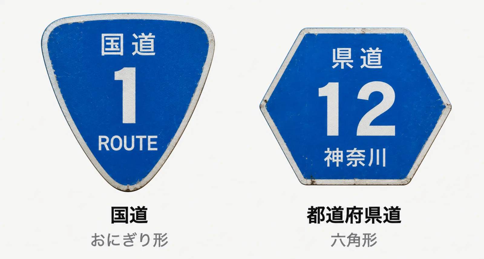 左に国道番号の標識、右に都道府県道番号の標識を並べた図。国道は上に「国道」、中央に番号、下に「ROUTE」と書かれた、下がすぼまったおにぎり形。都道府県道は上に「県道」、中央に番号、下に都道府県名が入った六角形。